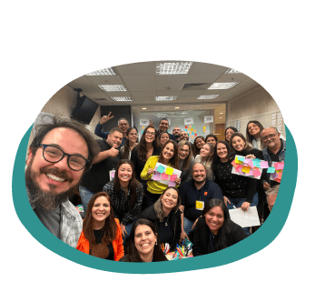 Grupo de pessoas sorrindo em uma selfie descontraída após dinâmica de equipe conduzida por Alex Camargo