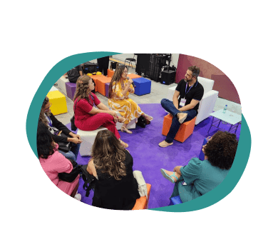 Tiago Gusmão facilitando uma roda de conversa com participantes sentados em pufes coloridos em um ambiente descontraído